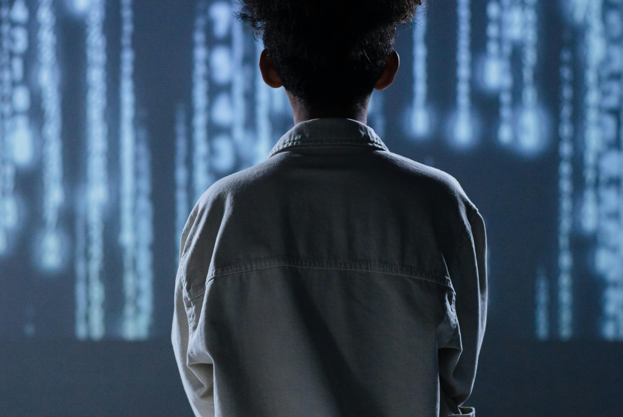 student standing in front of digital data representing ai course