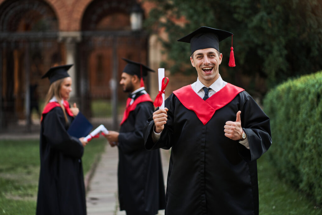 happy graduates in graduation growns holding certificate
